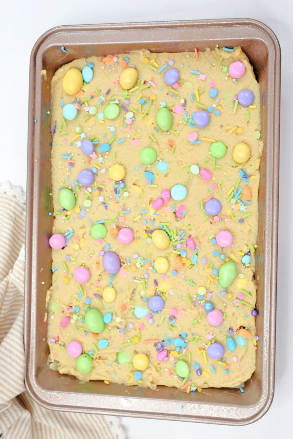 cookie dough with pastel candies in a sheet pan