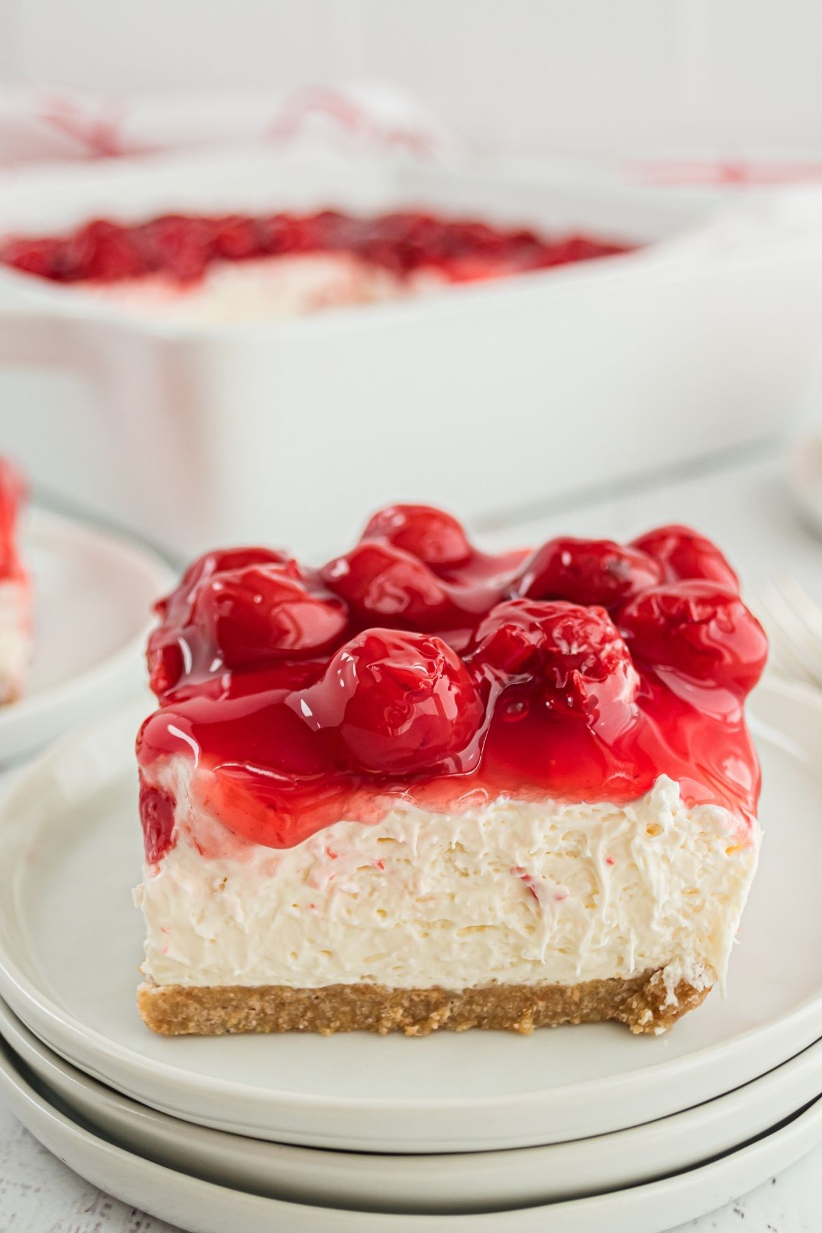 cheesecake square with graham cracker crust and cherries on top