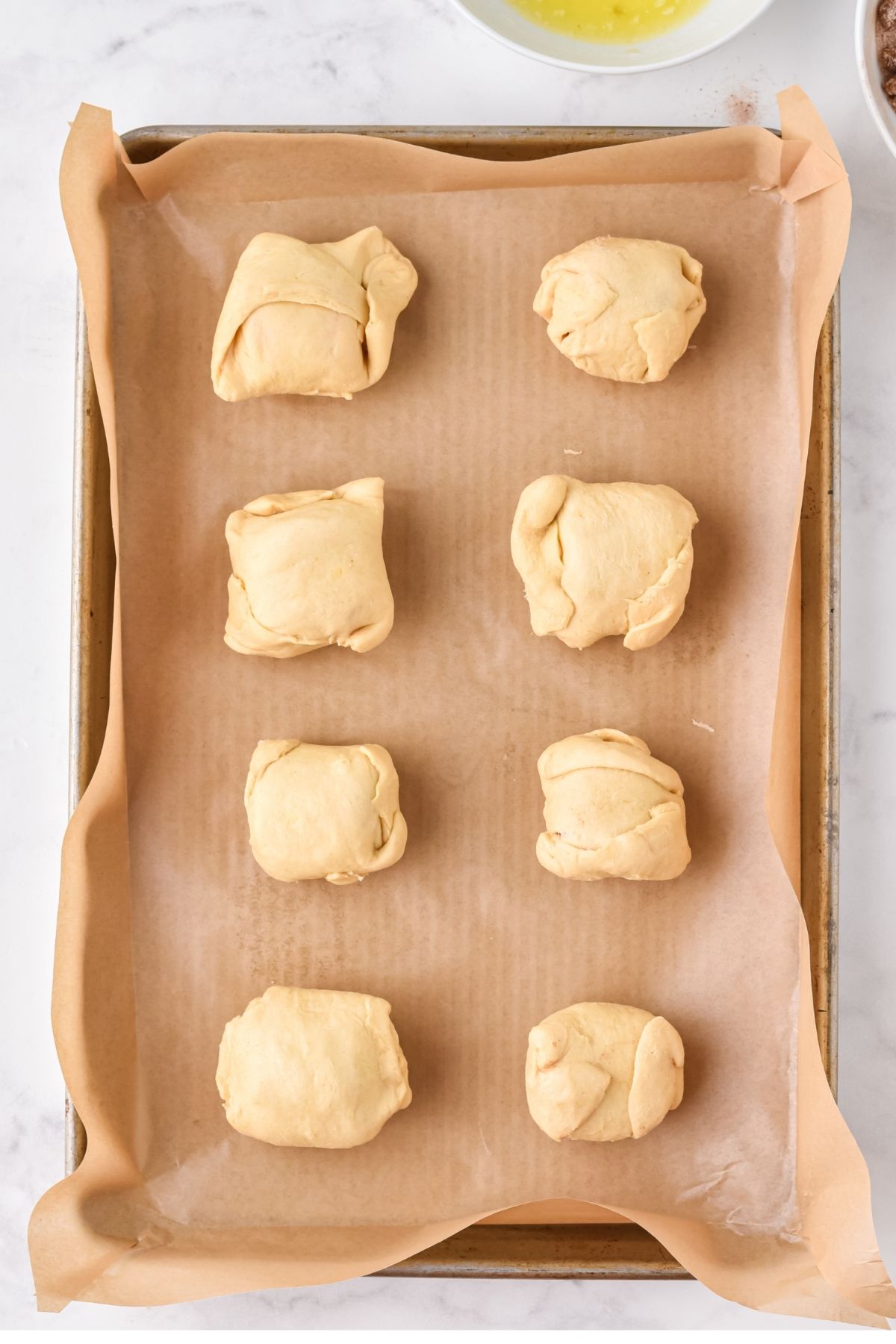 crescent rolls closed into round rolls on baking sheet