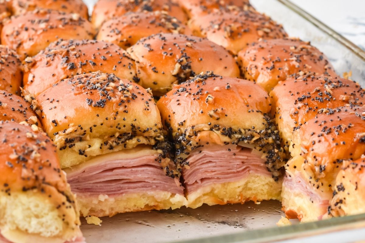 baked sliders in baking dish showing ham and cheese on inside