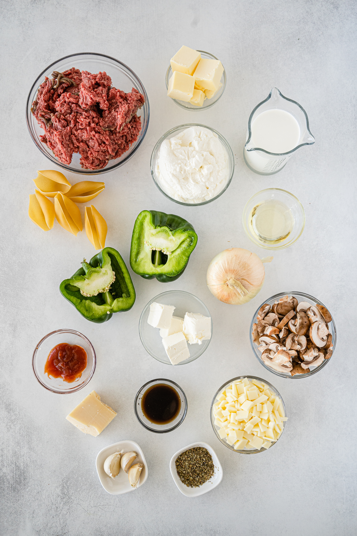 Ingredients of philly cheesesteak stuffed shells on a white counter