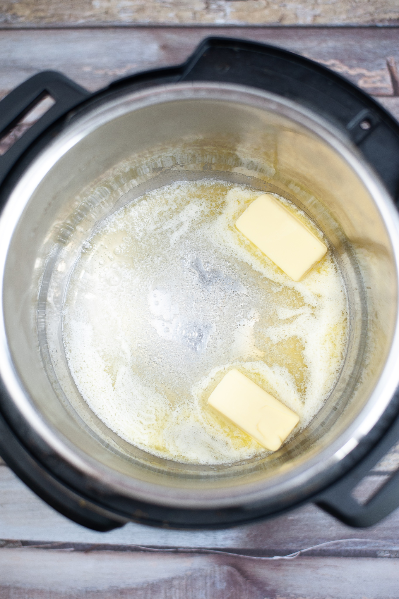 Instant pot with melted butter in the bottom.