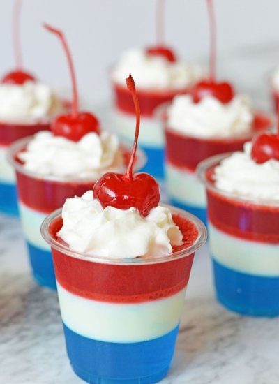 red white and blue jello shots with whipped cream and cherries
