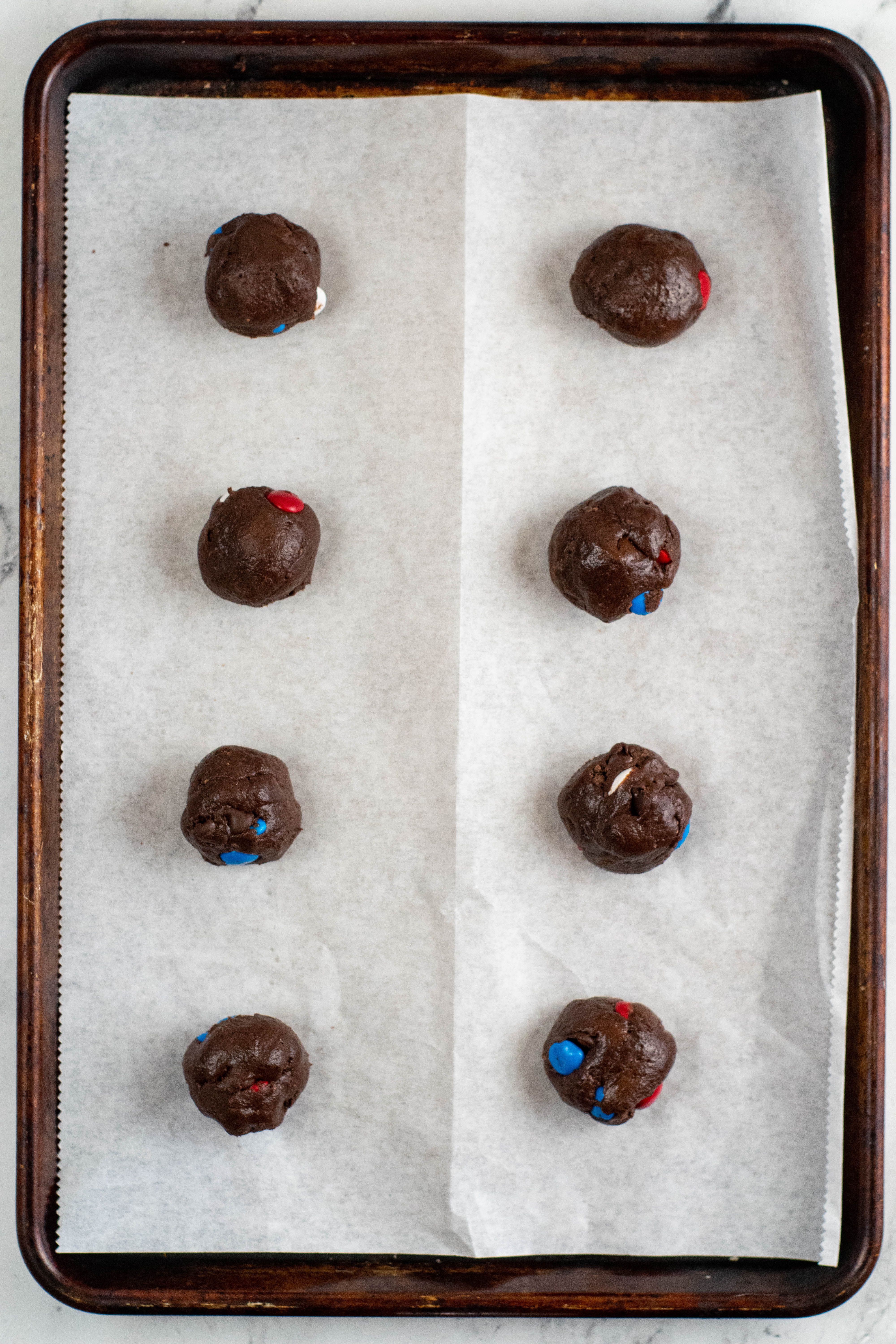 chocolate cookie balls on baking sheet