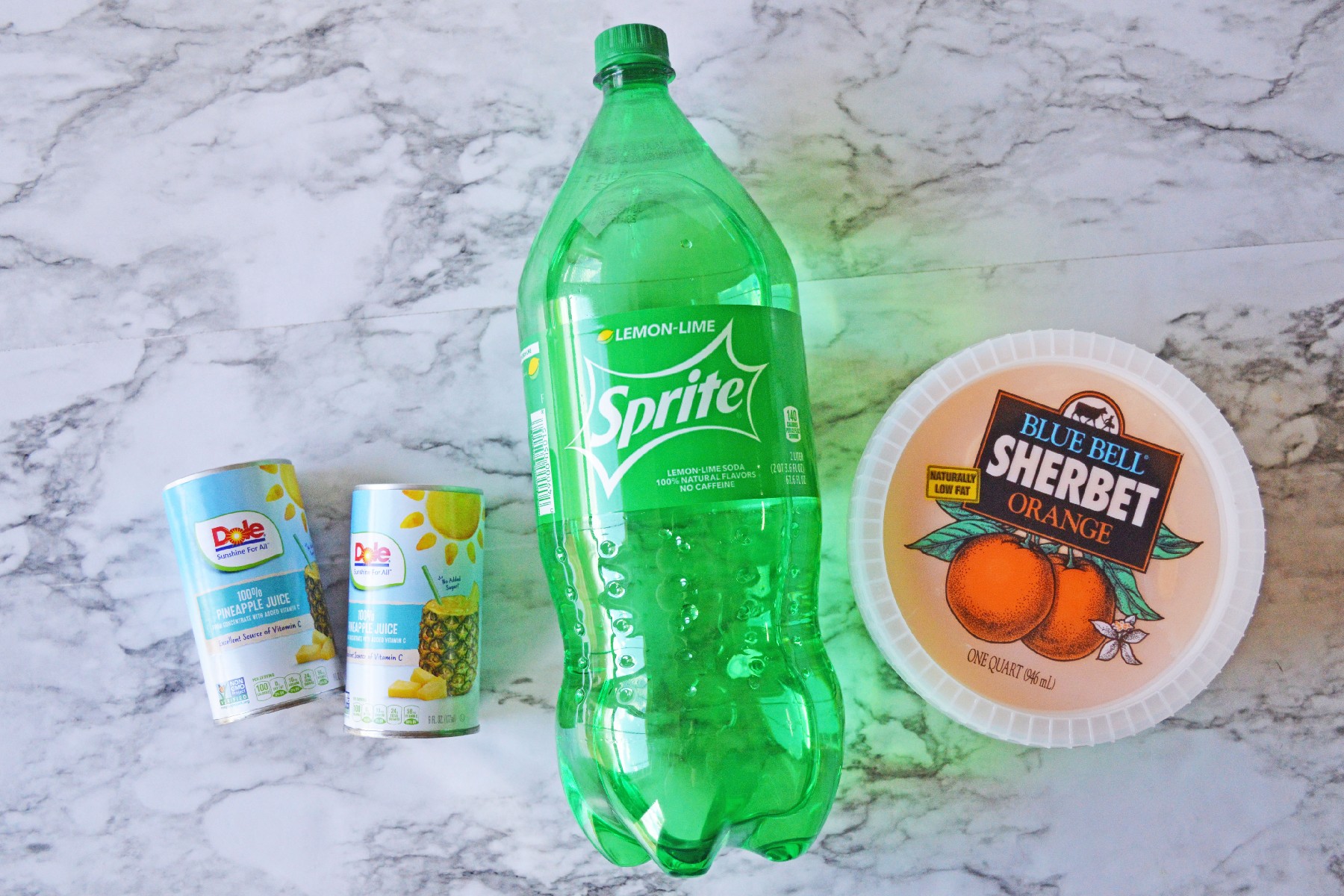 Ingredients of orange sherbet punch. These are pineapple juice, orange sherbet, and sprite. 
