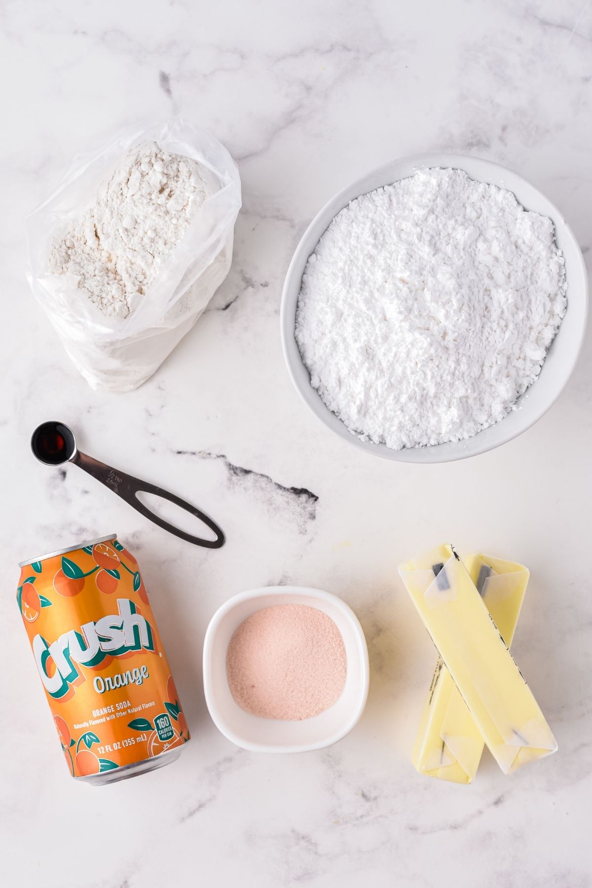 ingredients on counter: cake mix, powdered sugar, 2 sticks of butter, Orange gelatin, Crush orange soda