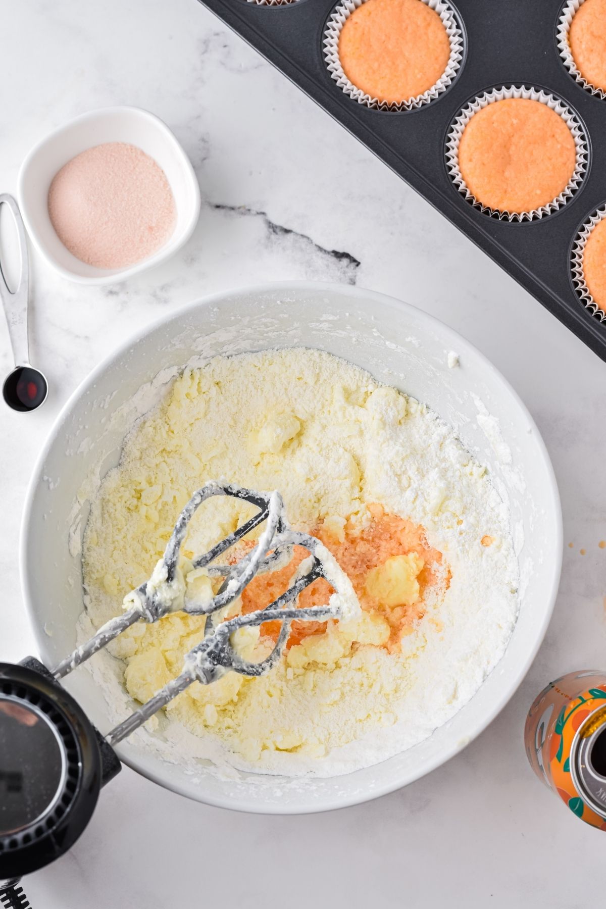 mixing bowl with frosting ingredients and a mixer