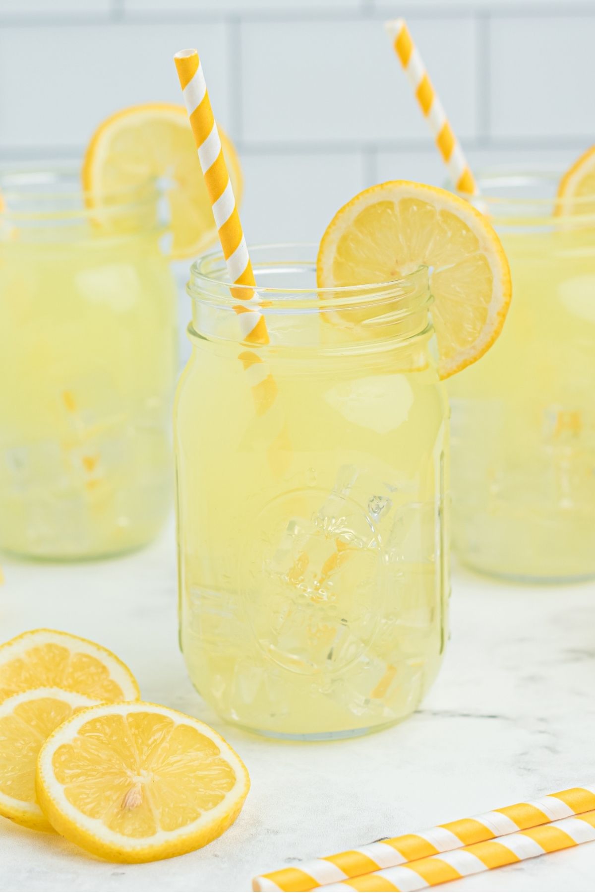 three mason jars with lemonade and sliced lemon