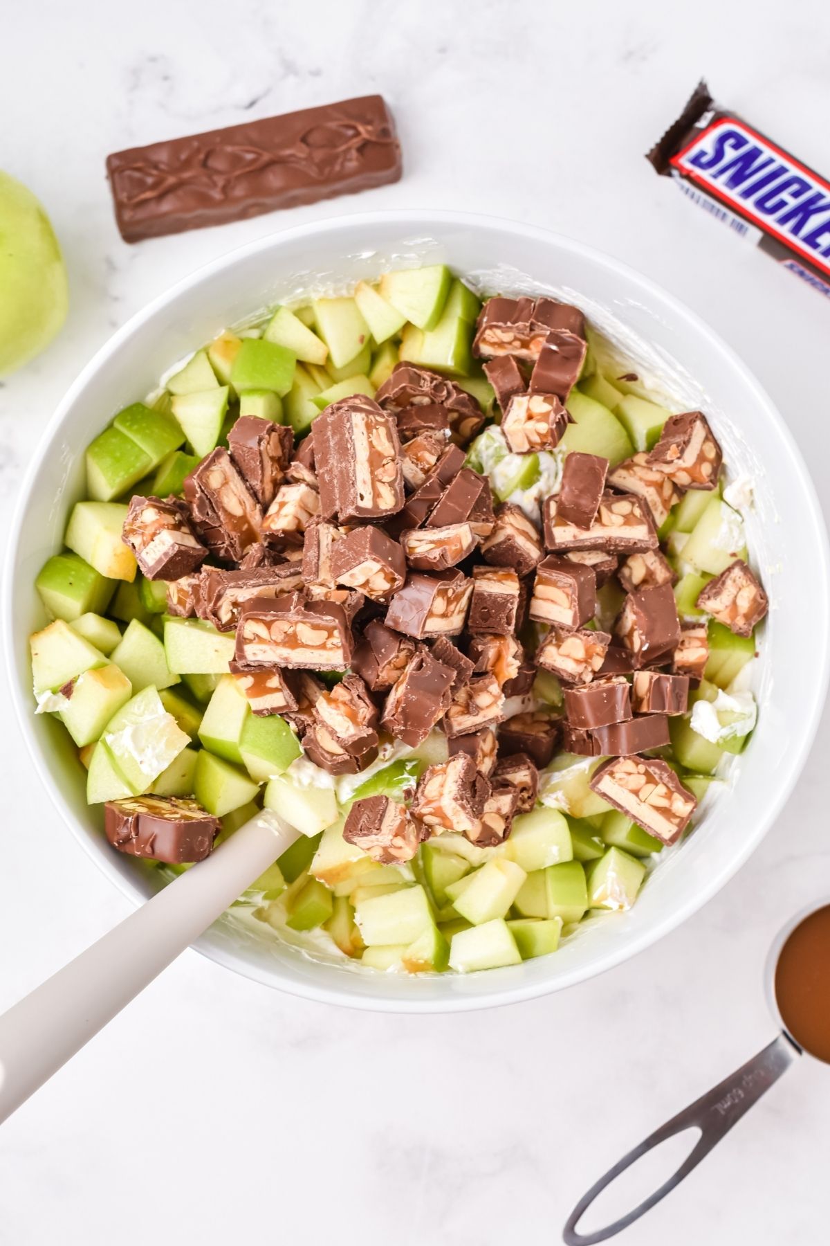 chopped green apples and chopped Snicker's in bowl