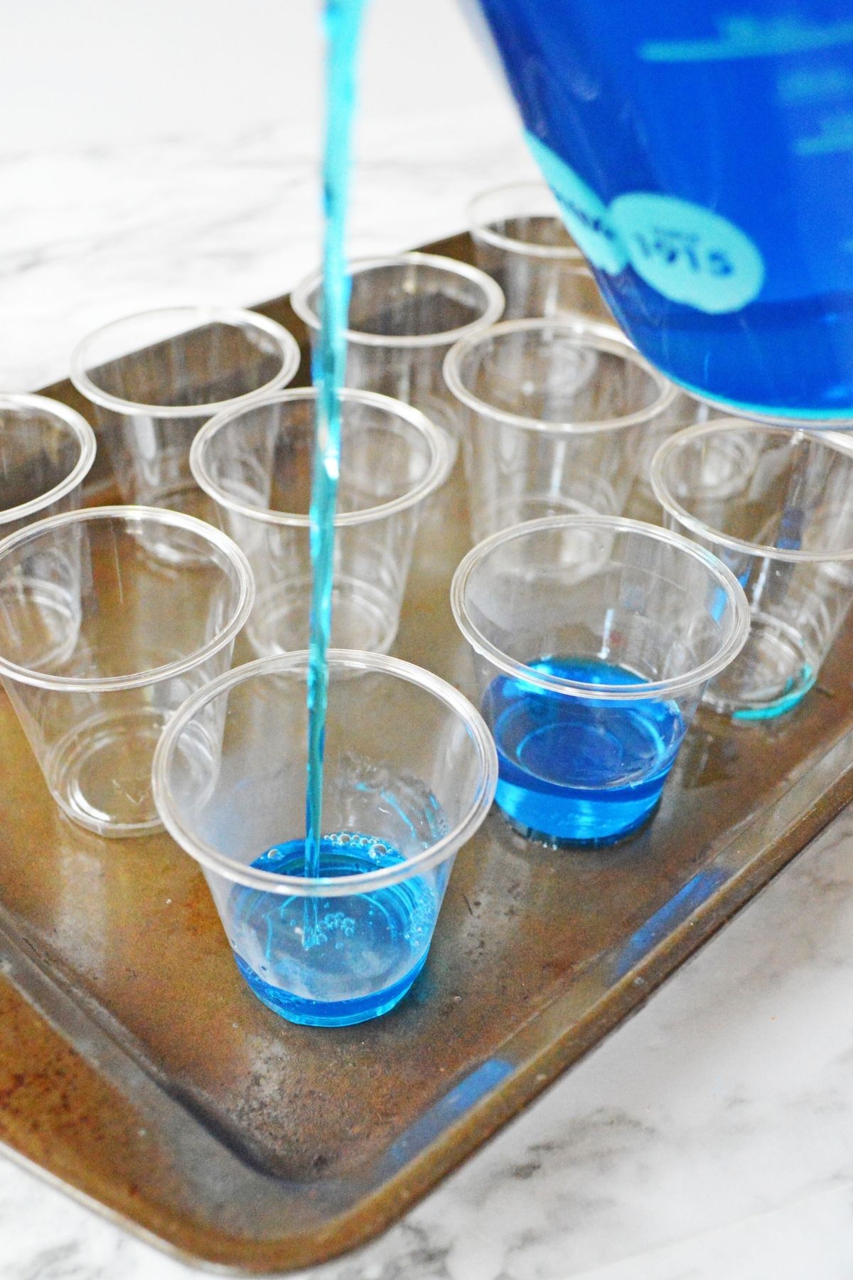 pouring blue jello into small cups