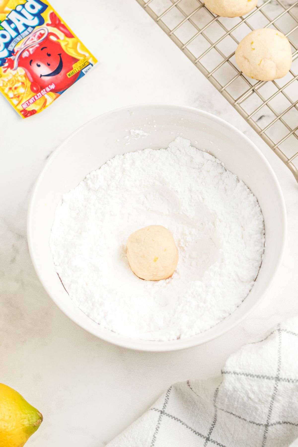 White bowl with confectioner's sugar and lemon kool-aid in it.