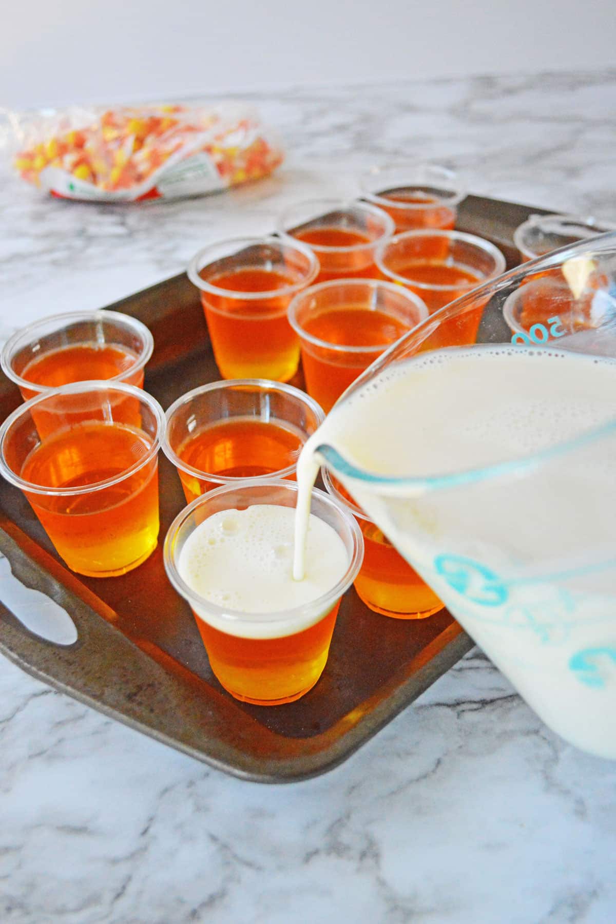 A mixture of sweetened milk, vodka and whipped vodka for candy corn jello shots