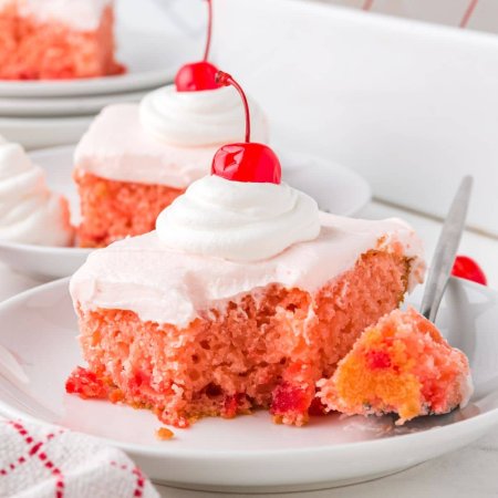 slices of cherry cake with cherry and whipped cream on top