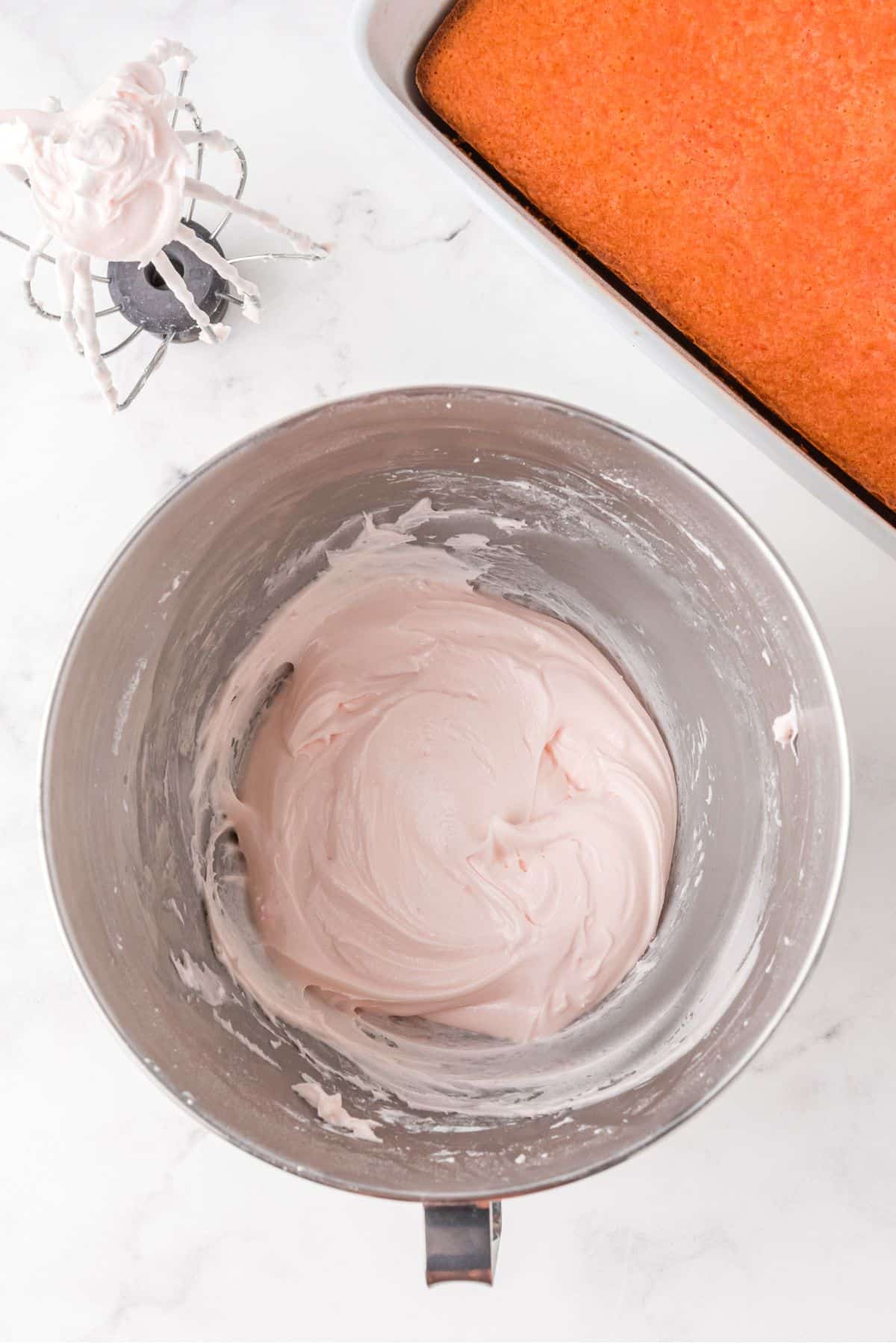 light pink frosting in mixing bowl