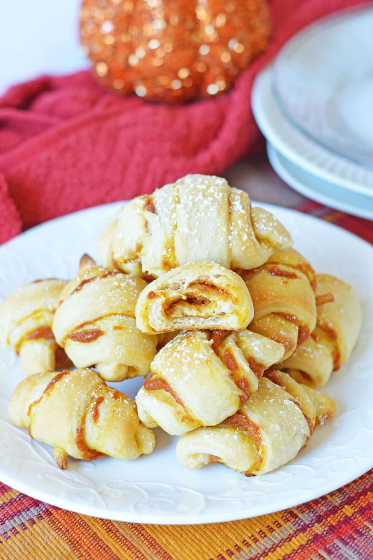 mini crescent rolls with pumpkin filling stacked on plate