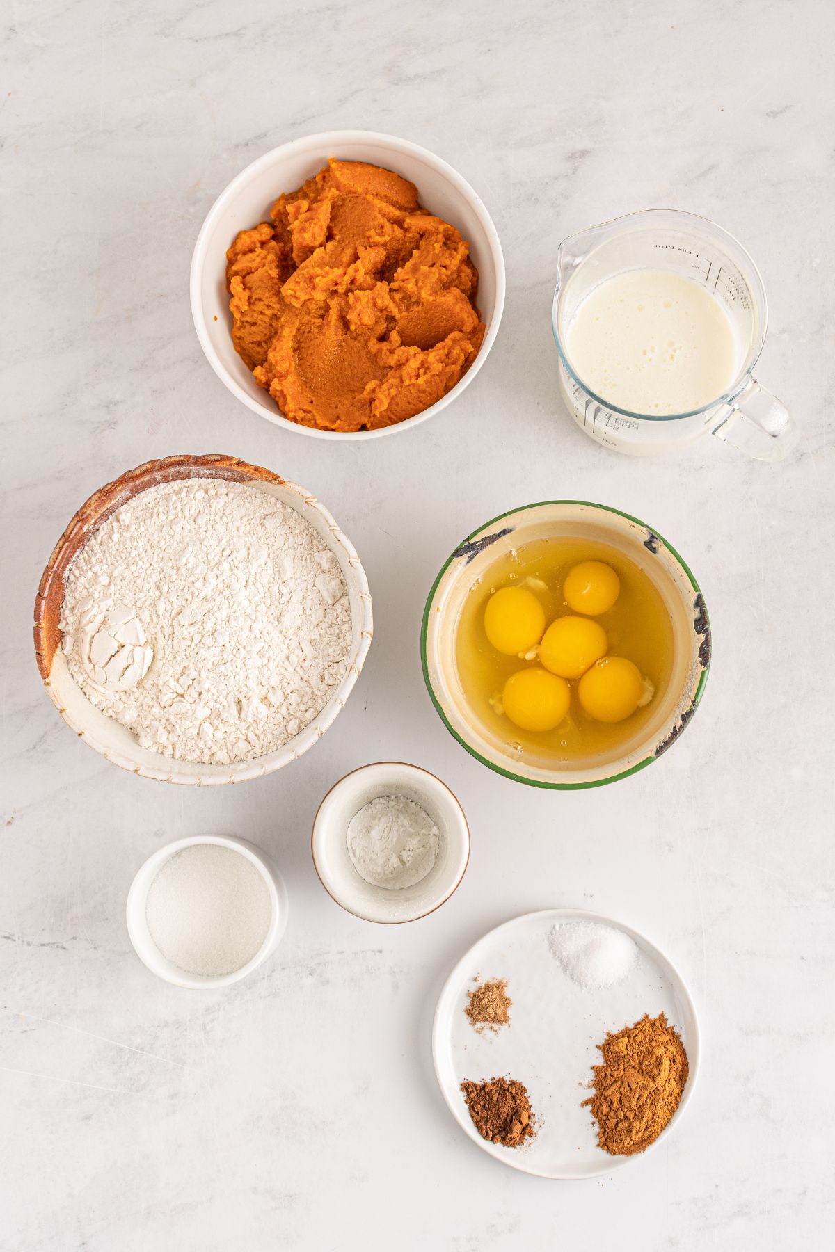 pumpkin puree, milk, eggs, flour, spices on counter