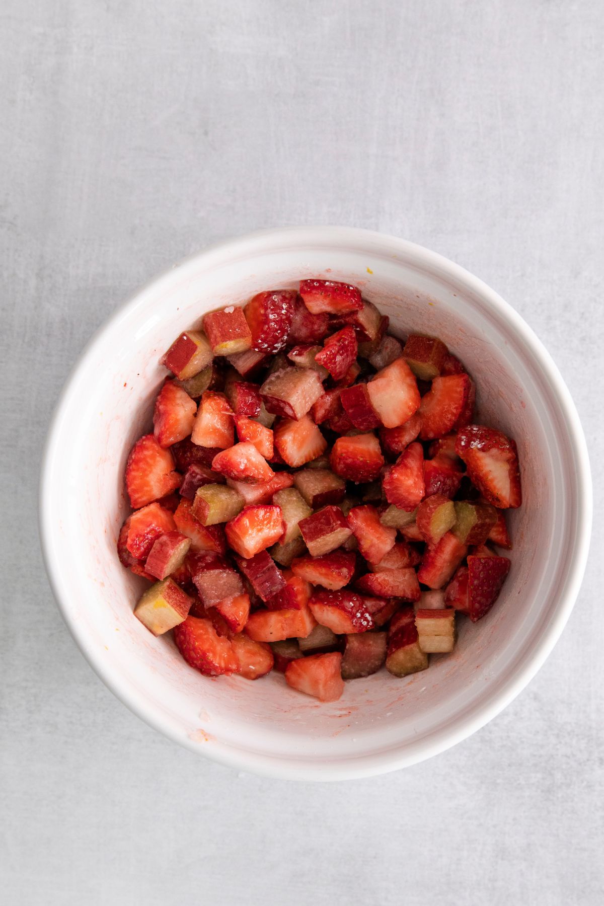 strawberries and rhubarb in white bowl