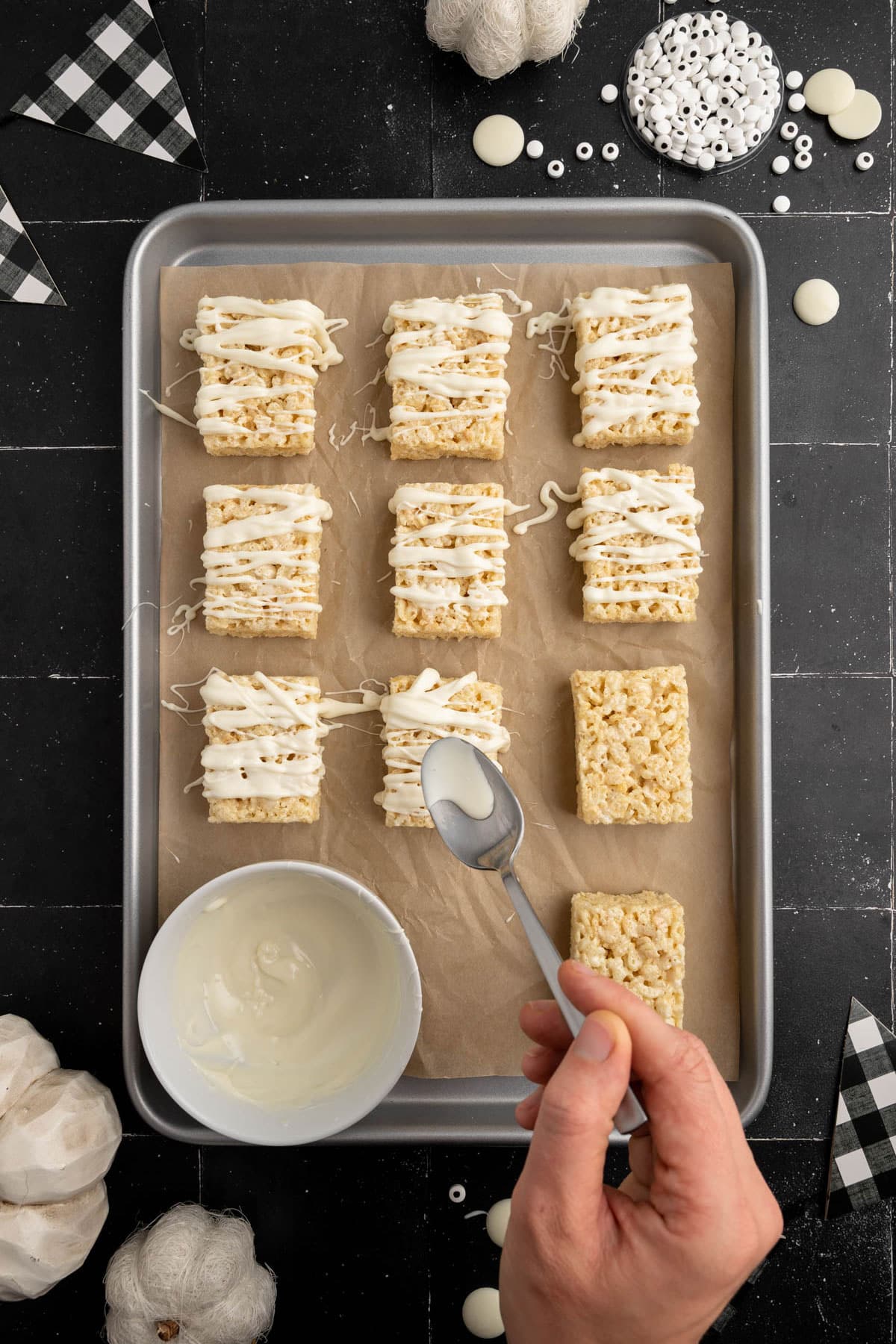 Process of preparing Mummy Rice Krispies Treats is to add a white dripping chocolate