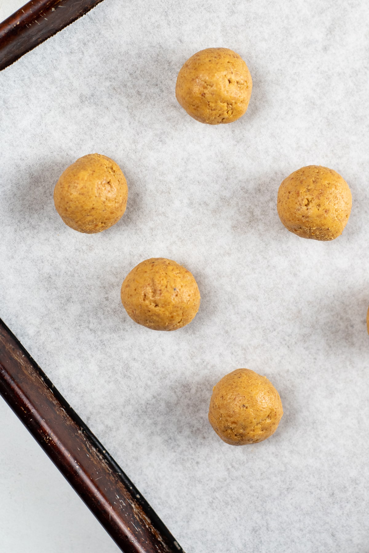 Next step for Pumpkin Truffles is to scoop out dough in 1 tablespoon scoops and roll into balls, placing on the prepared baking sheet until all of the dough is in balls.