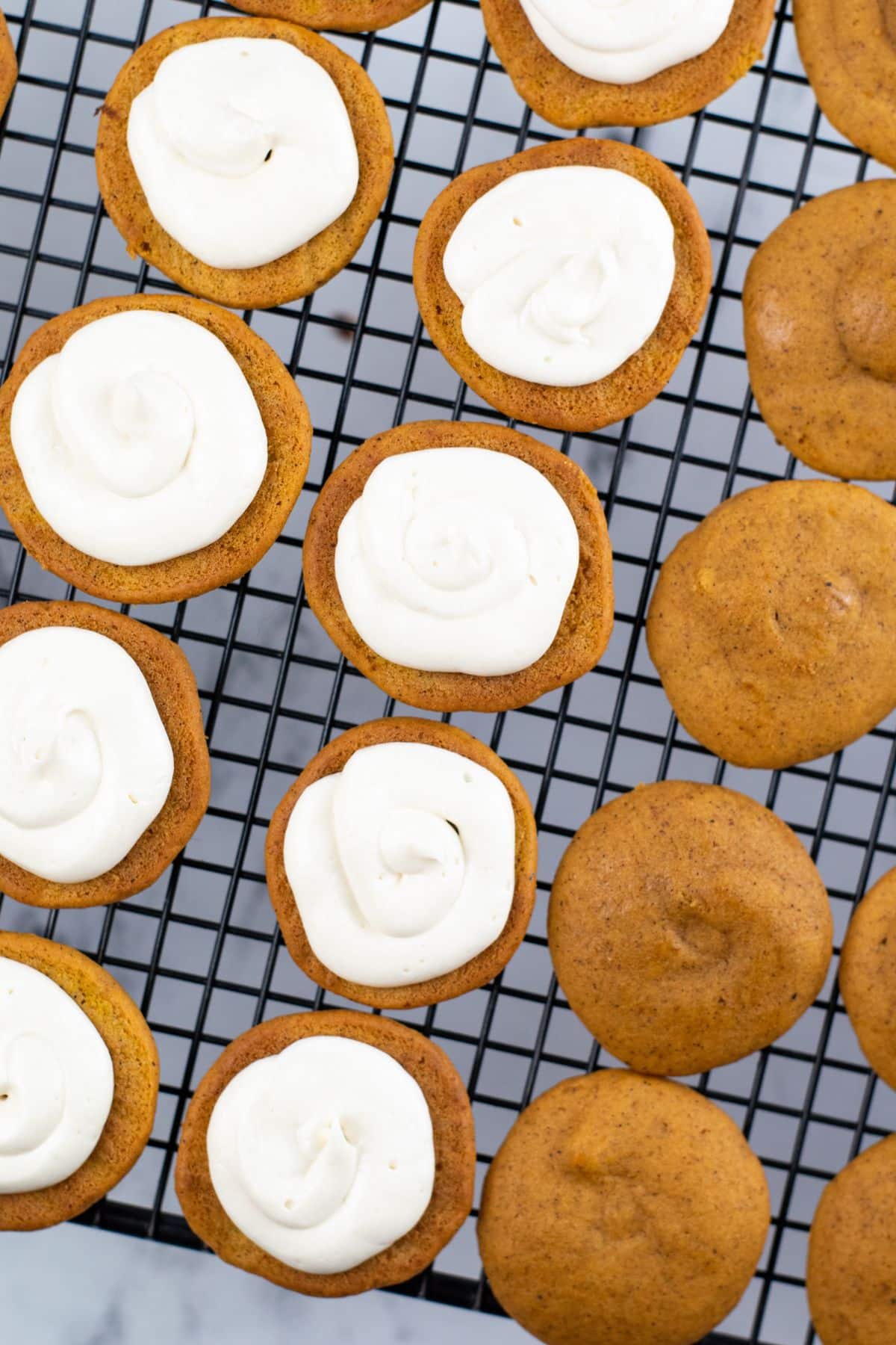 pumpkin bottoms with frosting on top laying on wire rack