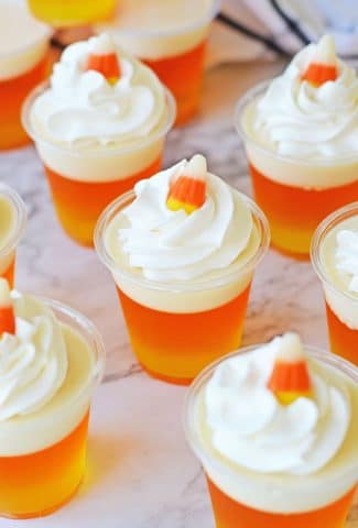 whipped cream topped (with candy corn) orange and yellow jello shots