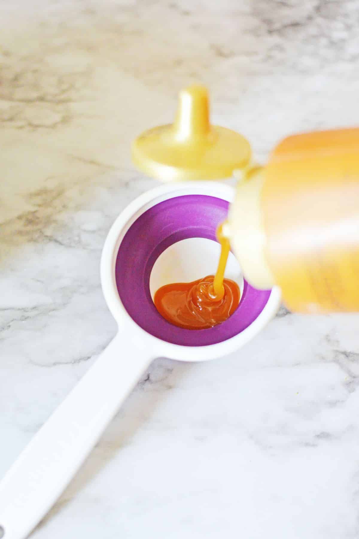 pour caramel into measuring spoon