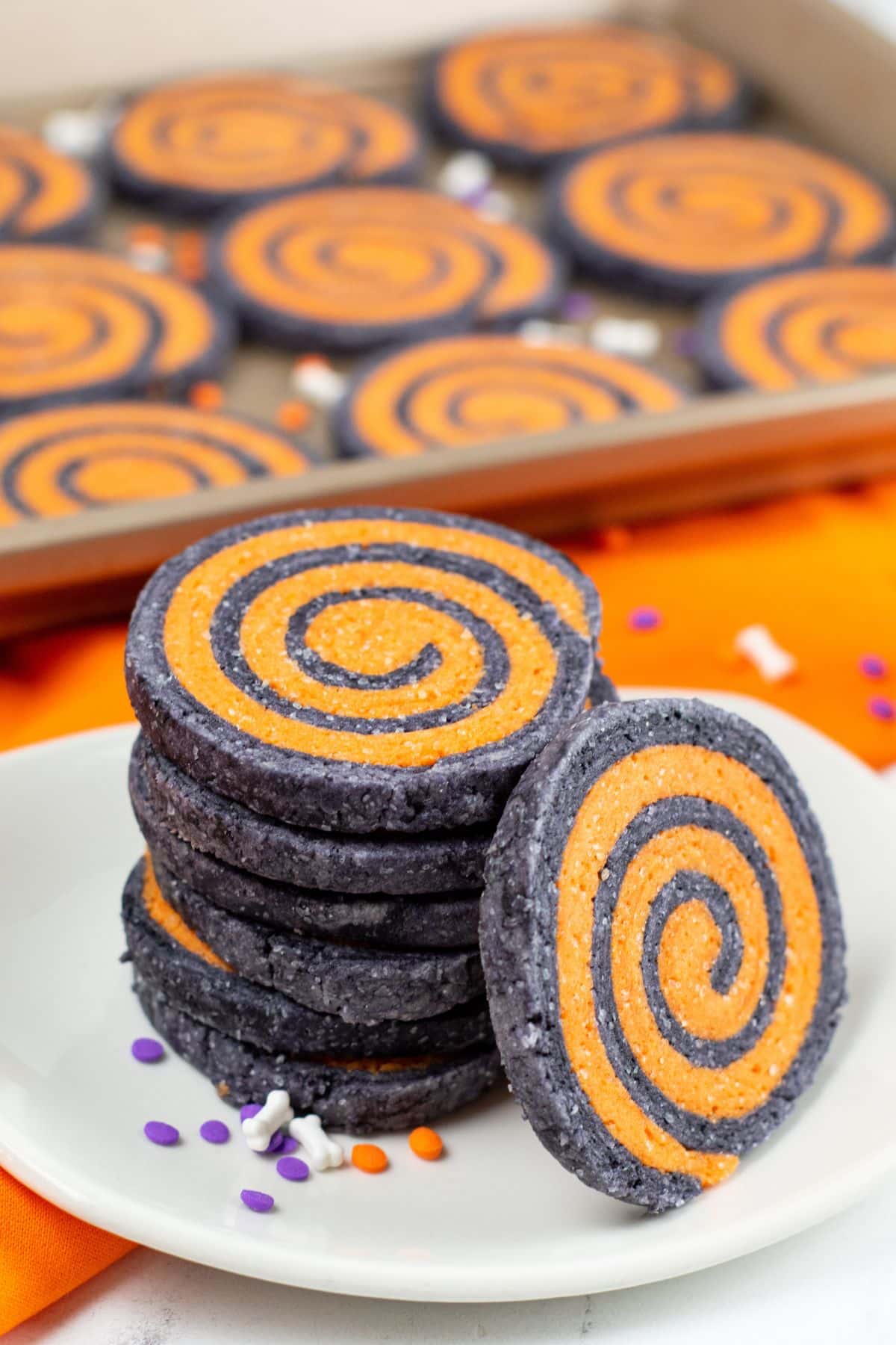 purple and orange swirl cookies stacked on a plate