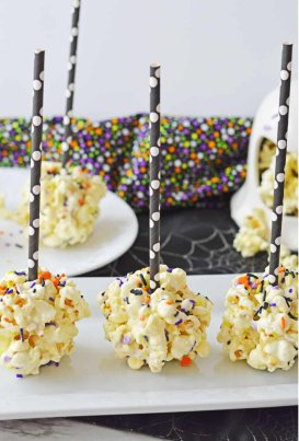 popcorn balls on black and white straws