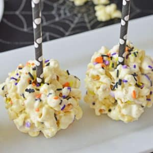 two popcorn balls with paper straws