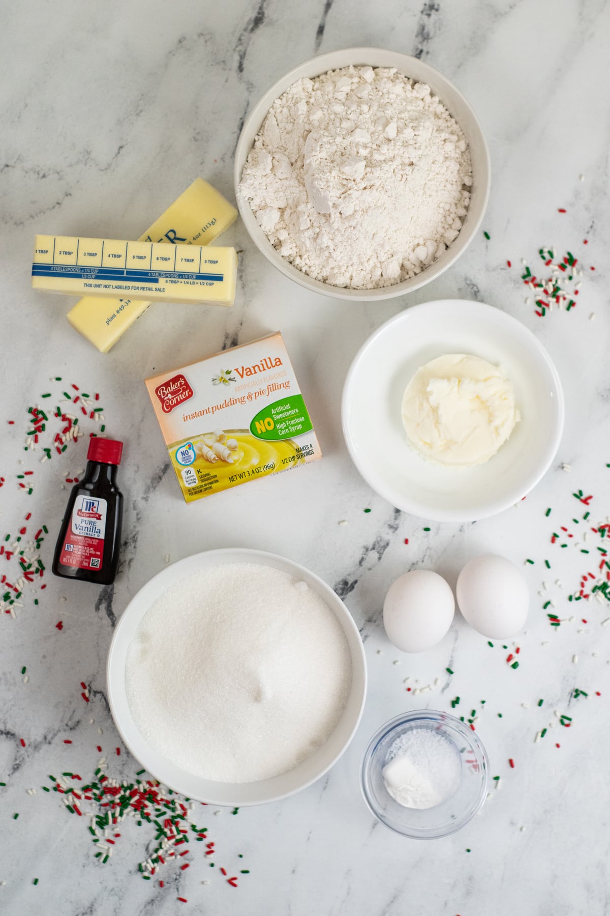 Christmas Sprinkle Cookie Recipe ingredients include ¾ Cups Butter – softened , ¼ Cup Shortening, 1 ½ Cups Sugar 2 Eggs, 1 ½ tsp Vanilla, 2 ½ Cups Flour, 1 Box Instant Vanilla Pudding , 1 tsp Baking Powder, ½ tsp Salt and 1 Cup Green, and Red & White Jimmie Sprinkles