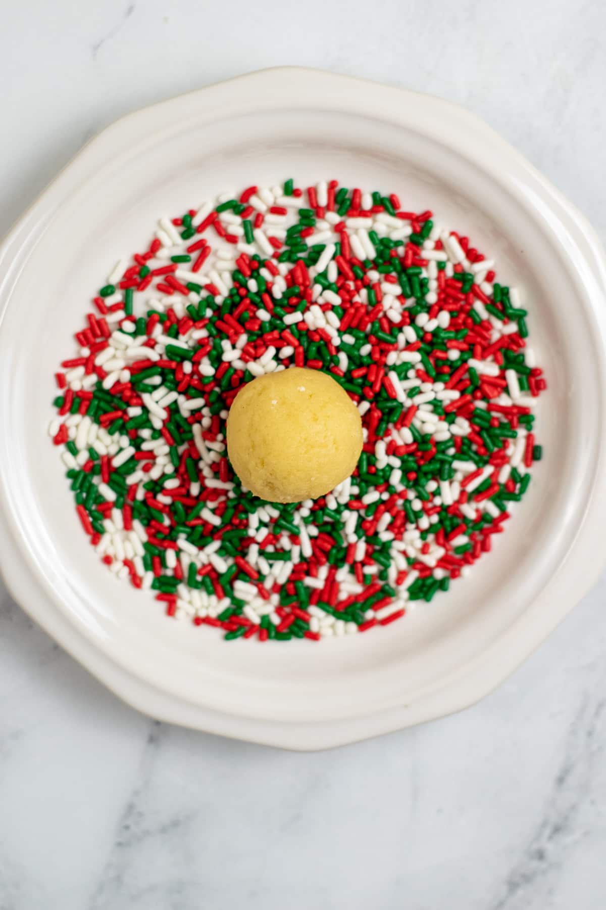 Another process in Christmas Sprinkle Cookie Recipe is to roll the dough ball over sprinkles