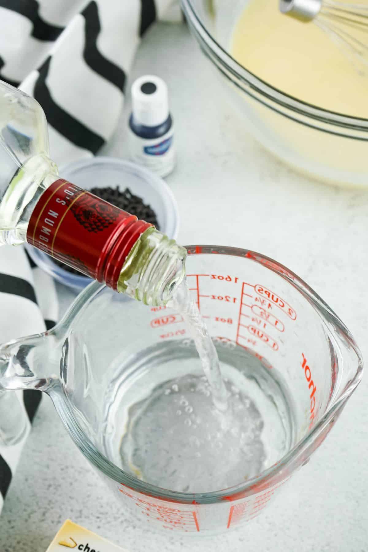 vodka pouring into measuring cup