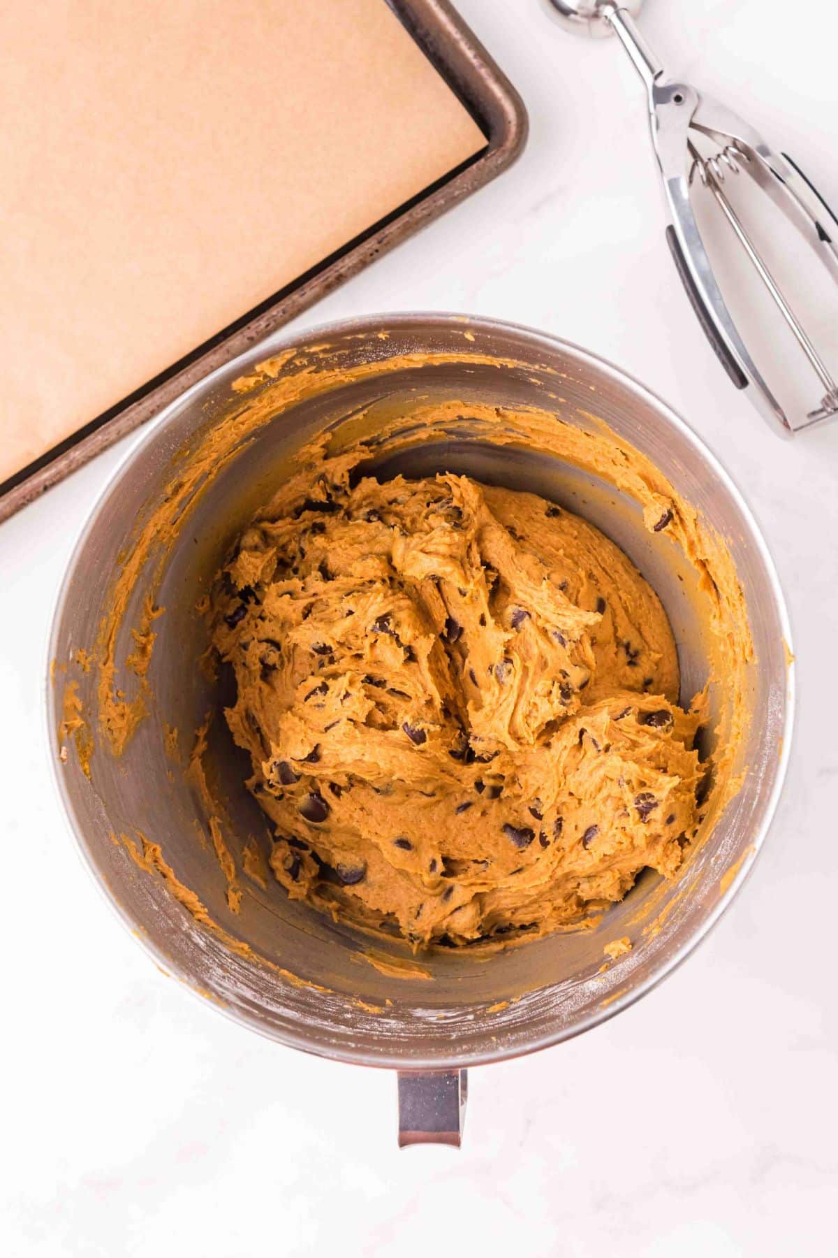 pumpkin cookie dough with chocolate chips mixed in silver bowl
