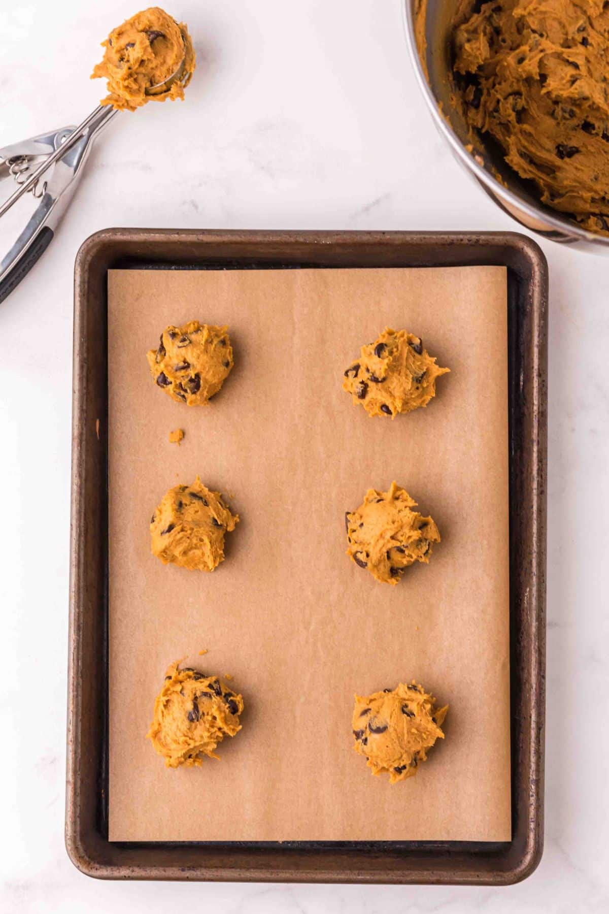 round balls of cookie dough on baking sheet lined with parchment