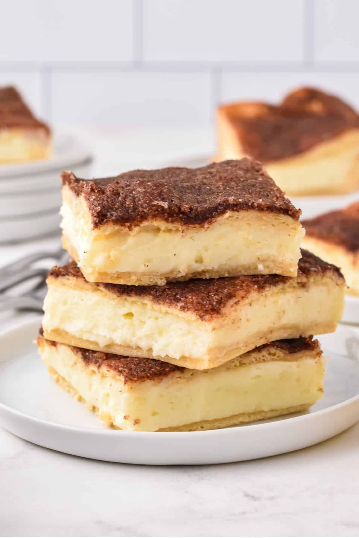 square cheesecake bars stacked on top of one another on a plate