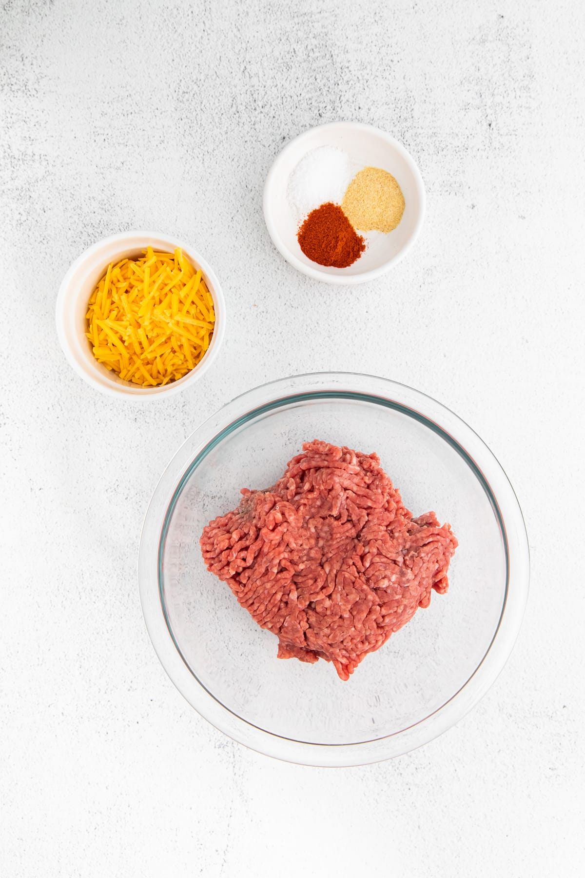 Air Fryer Juicy Lucy Burgers ingredients include ground beef, garlic powder, paprika, kosher salt, and cheddar cheese