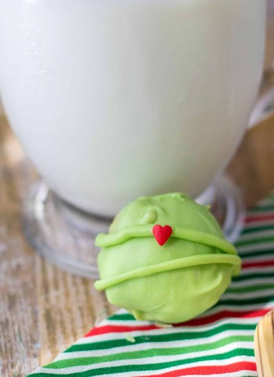 light green ball with red candy heart next to glass of milk