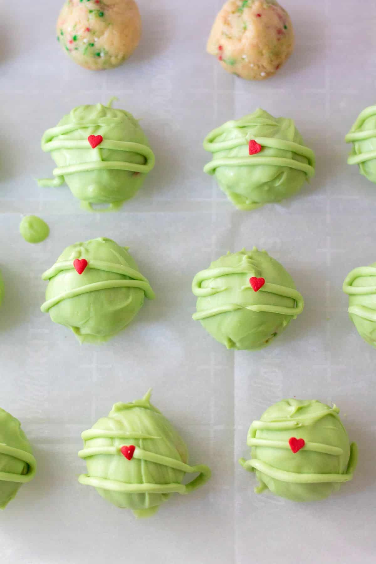 green truffles with red hearts on parchment