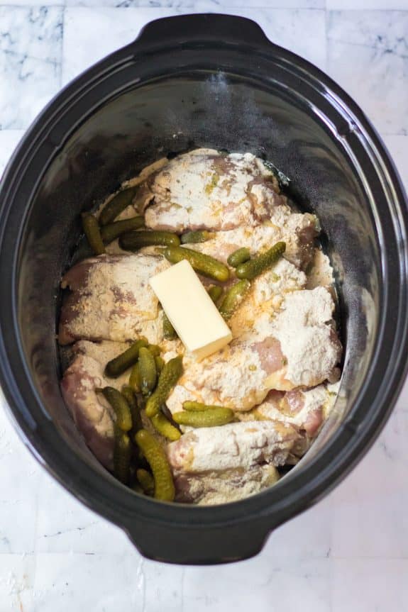 Adding all ingredients in a pot for slow cooker pickle chicken