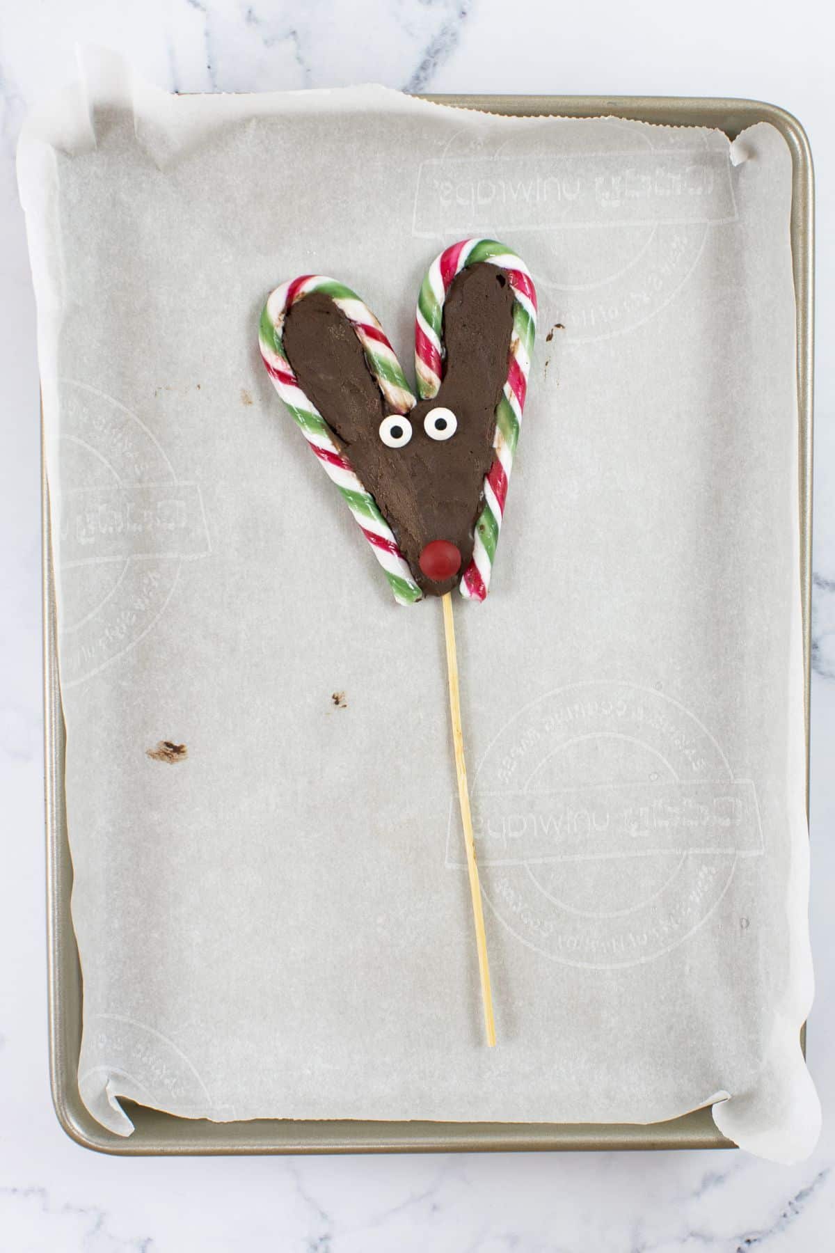 one candy cane reindeer on parchment paper