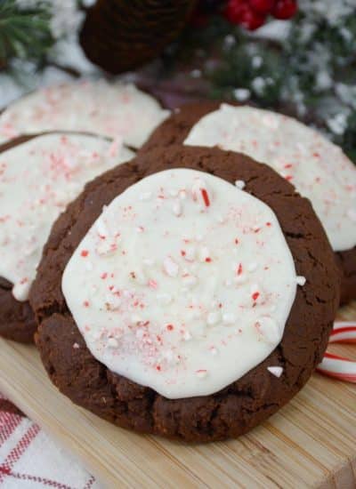 Chocolate peppermint cookies with white icing on a cutting board.
