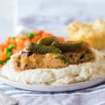 slow cooker pickle chicken on mashed potatoes with pickles on top