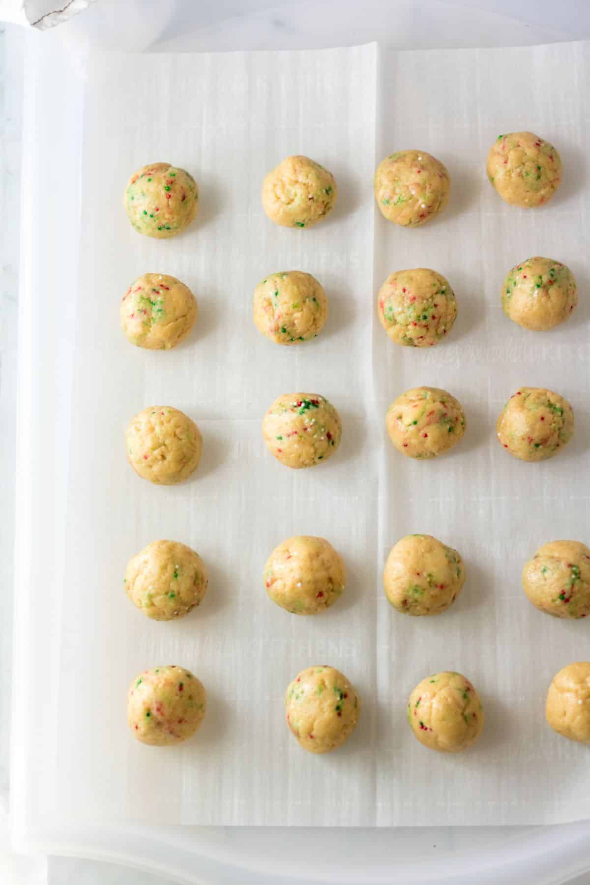 light brown cookie balls on parchment