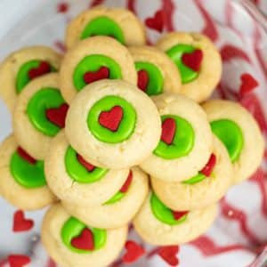 stack of Grinch thumbprint cookies on clear plate