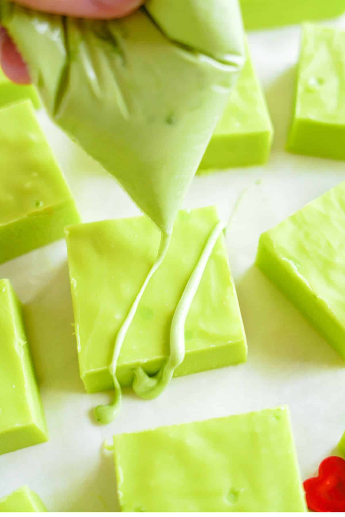 piping bag drizzling green chocolate on fudge
