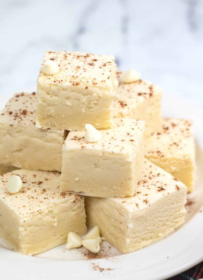 squares of eggnog fudge stacked on plate