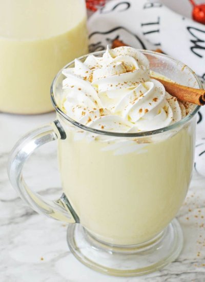 glass of eggnog with whipped cream and cinnamon