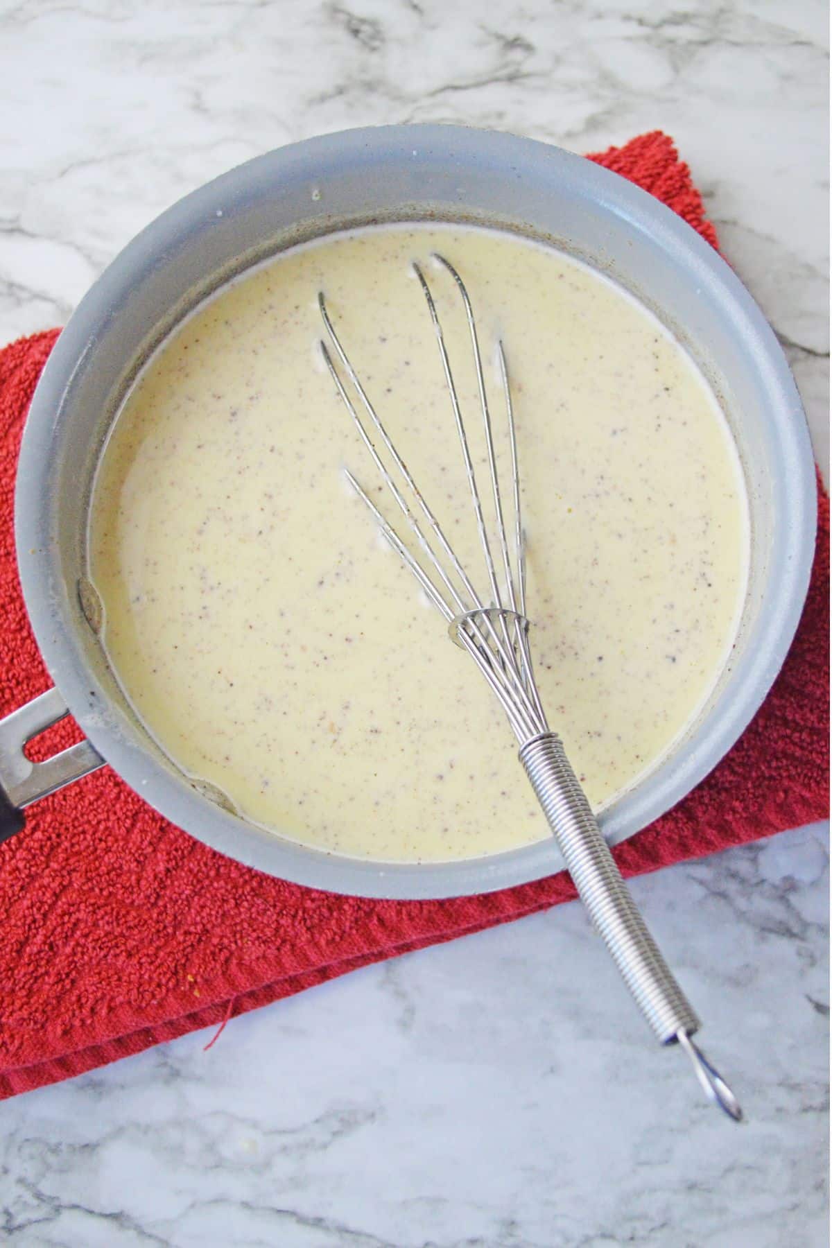 egg nog with whisk in saucepan