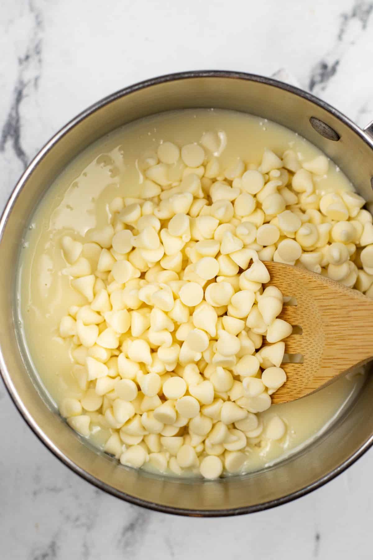 white chocolate chips in sauce pan with condensed milk