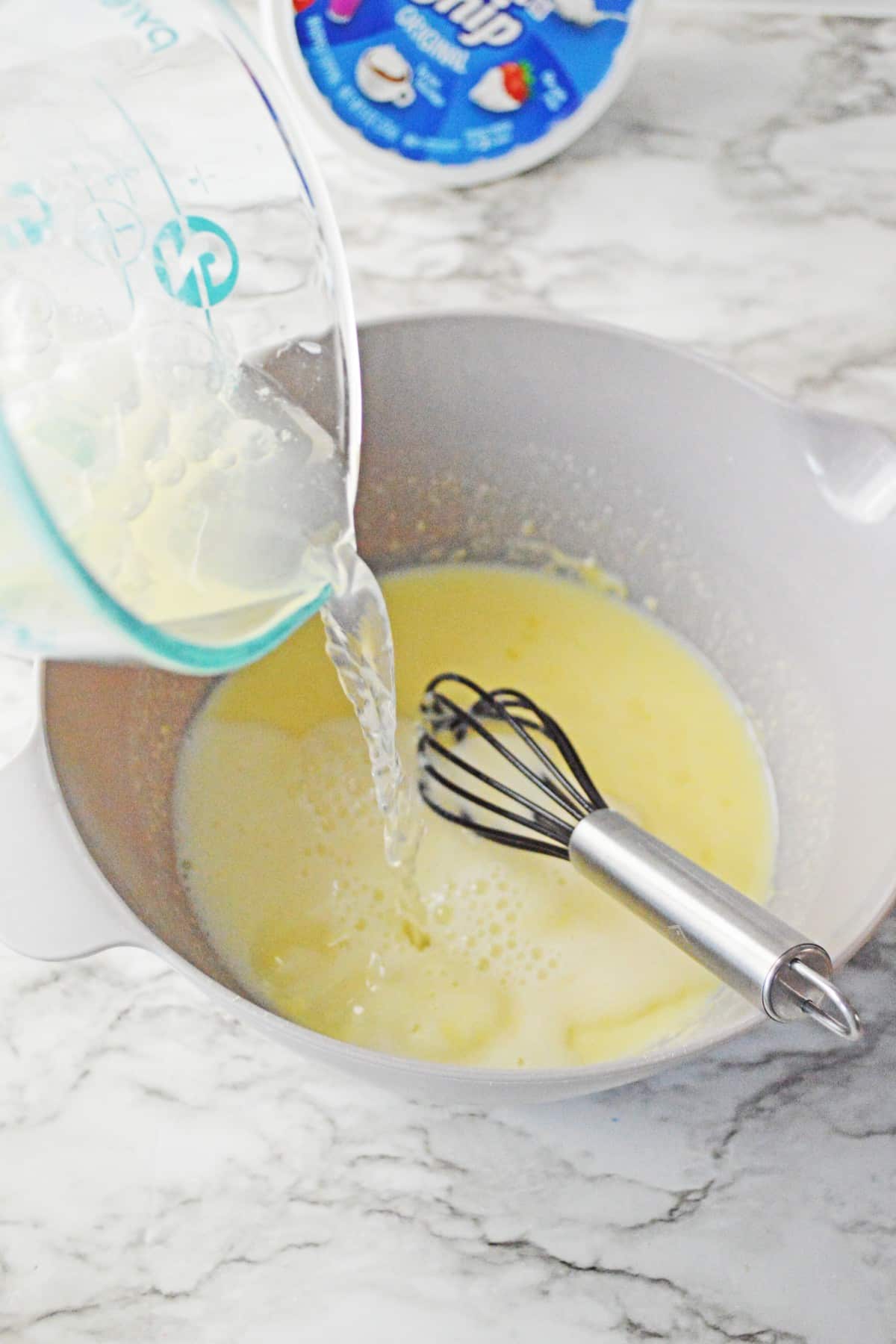 Process of preparing champagne cheesecake shooter is to mix and whisk together cheesecake pudding mix, milk, and champagne, stirring until well combined.